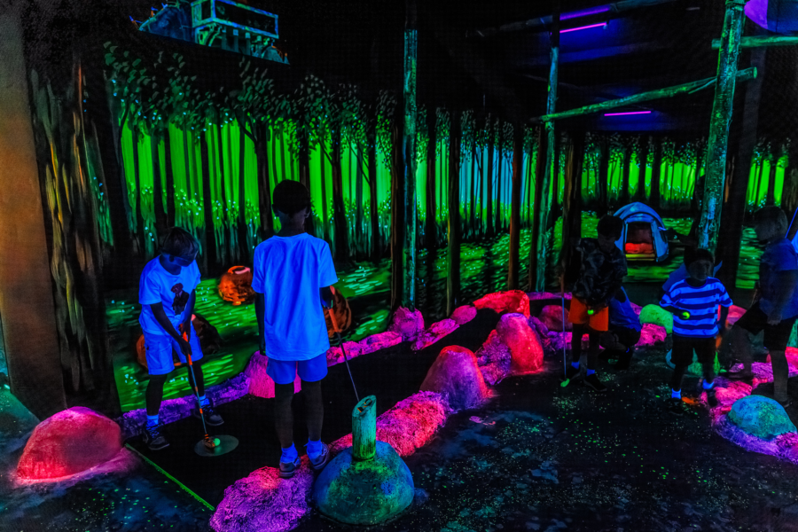 Kinderen proberen een hole-in-one te slaan op de Golf in the Dark baan