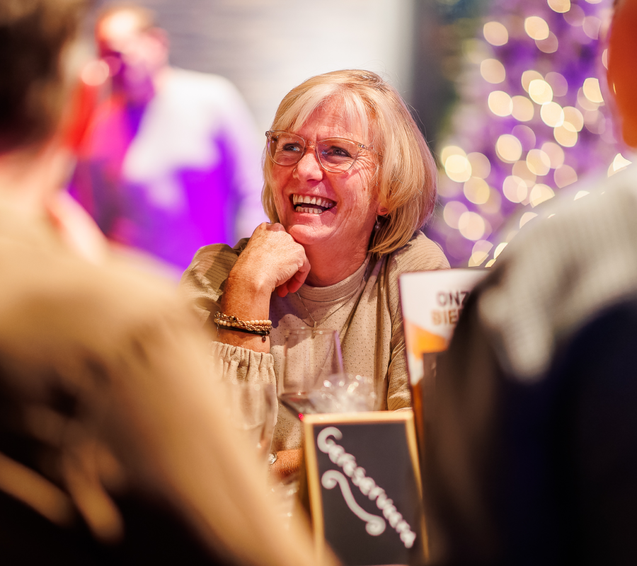 Een lachende vrouw die aan het genieten is van een kerstborrel in Mauk
